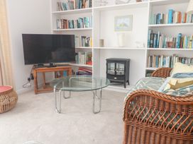 A living room with a television and bookshelves at Flat 2, Moonrakers St. Ives