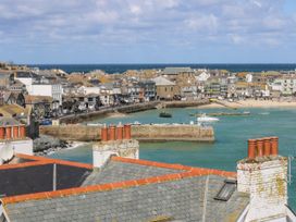 A coastal view with boats and buildings near the beach at Flat 2, Moonrakers in St. Ives