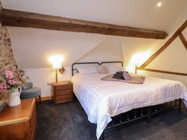 A bedroom with a bed and side table at The Granary in Welshpool