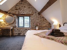 A bedroom with a bed and a table at The Granary in Welshpool