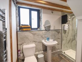 A bathroom with a sink, toilet, and shower at The Granary in Welshpool