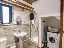A bathroom with a shower and washing machine at The Granary in Welshpool