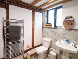 A bathroom featuring a toilet, sink, towel rail, and window at The Granary in Welshpool
