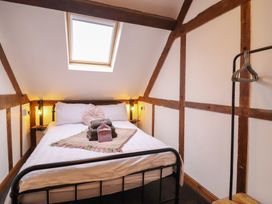 A bedroom with a bed and a clothing rack at The Granary in Welshpool