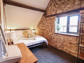 A bedroom with a bed and wooden furniture at The Granary in Welshpool