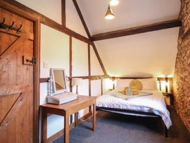 A bedroom with a bed and a wooden table at The Granary in Welshpool