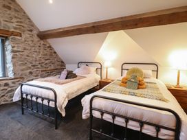 A bedroom with two beds and wooden beams at The Granary in Welshpool