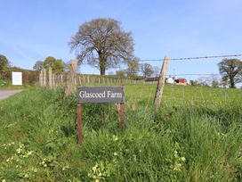 A sign for Glascoed Farm in a grassy area near a tree at Glascoed Farm in Llangyniew near Llanfair Caereinion