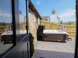 A garden with a hot tub and towels hanging near a wooden fence at The Granary in Llangyniew near Llanfair Caereinion