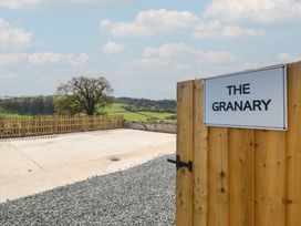An outdoor area with a gravel path and a sign at The Granary in Llangyniew near Llanfair Caereinion