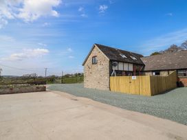 An outdoor area with a gravel surface and a building at The Granary in Llangyniew near Llanfair Caereinion