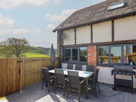 An outdoor dining area with a table and chairs at The Granary in Llangyniew near Llanfair Caereinion