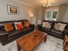 A living room with two brown leather sofas a wooden coffee table and a floor lamp at Sparrow House in Alnwick