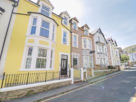 A street with a row of terraced houses featuring bay windows and small fences at DownTown - Manhattan House in Llandudno