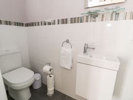 A small bathroom with a toilet sink towel and toilet paper at DownTown - Manhattan House in Llandudno