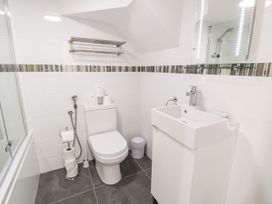 A bathroom with a toilet sink mirror and towel rack at DownTown - Manhattan House in Llandudno