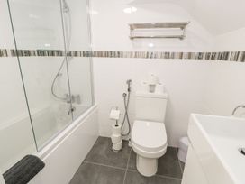 A bathroom with a bathtub shower combo a toilet and a sink at DownTown - Manhattan House in Llandudno