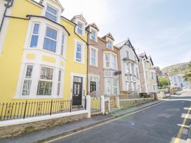 A street view with a row of three-story houses with front doors and windows at MidTown - Manhattan House in Llandudno