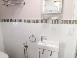 A bathroom sink with a faucet a mirror and a towel rack at MidTown - Manhattan House in Llandudno