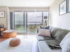 A living room with a sofa and large windows at Hafod Y Bryn in Harlech