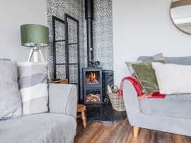 A living room with a fireplace and sofa at Hafod Y Bryn in Harlech