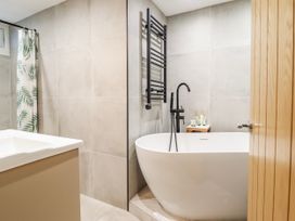 A bathroom with a bathtub and shower curtain at Hafod Y Bryn in Harlech