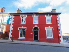 A red house with windows and a door at Island House in Aberaeron