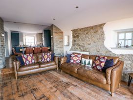 A living room with leather sofas and a dining area at Island House in Aberaeron