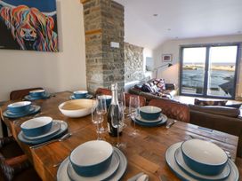 A dining room with a table set for a meal at Island House in Aberaeron