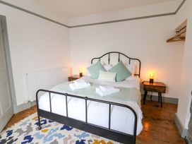 A bedroom with a bed, nightstand, and radiator at Island House in Aberaeron