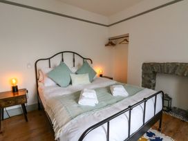 A bedroom with a bed and fireplace at Island House in Aberaeron
