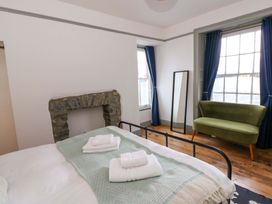 A bedroom with a bed and towels in Island House Aberaeron