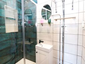 A bathroom featuring a shower, mirror, and sink at Island House in Aberaeron