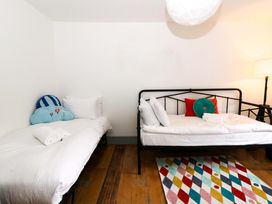 A bedroom with two beds and a rug at Island House in Aberaeron