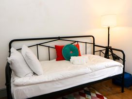 A bed with pillows and cushions in a bedroom at Island House in Aberaeron