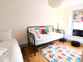 A bedroom with a metal bed, rug, lamp and window at Island House Aberaeron