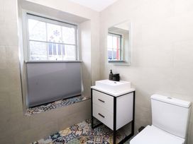 A bathroom with toilet, sink, and mirror at Island House in Aberaeron