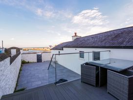 An outdoor area with a table and chairs overlooking the sea at Island House Aberaeron