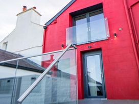 A building with a red wall and balcony at Island House in Aberaeron