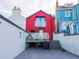 A red house with a balcony and stairs at Island House Aberaeron