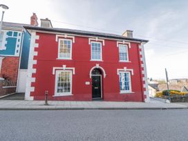 A red house with white trim and large windows at Island House Aberaeron