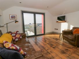 A living room with a sofa and TV at Island House in Aberaeron