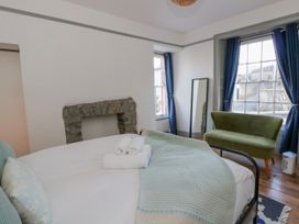 A bedroom with a bed and towels at Island House Aberaeron