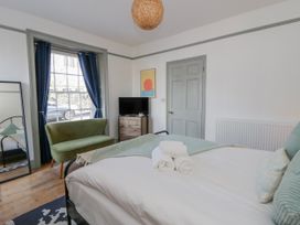 A bedroom with a bed and a chair at Island House in Aberaeron
