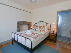 A bedroom with a bed and bathroom access at Island House Aberaeron