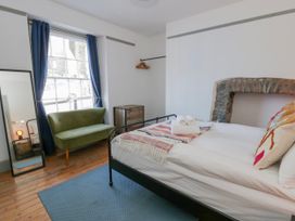 A bedroom with a bed and a sofa at Island House in Aberaeron