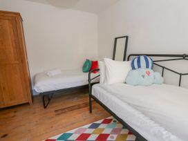 A bedroom with two beds and a wardrobe at Island House Aberaeron