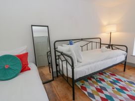 A bedroom with a bed and a mirror at Island House Aberaeron