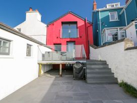 An outdoor area with a red house and deck at Island House Aberaeron