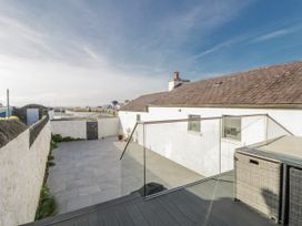 An outdoor space with a glass railing and paved area at Island House in Aberaeron